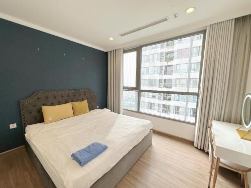 een slaapkamer met een bed, een bureau en een raam bij City Center 4BR Apartment in Hanoi