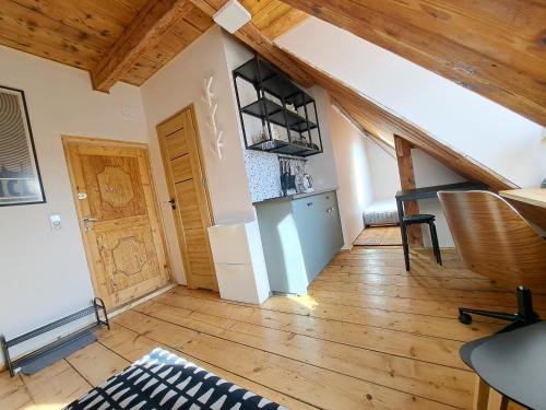 sala de estar con suelo de madera y techo de madera en Górskie apartmenty Kowary, en Kowary