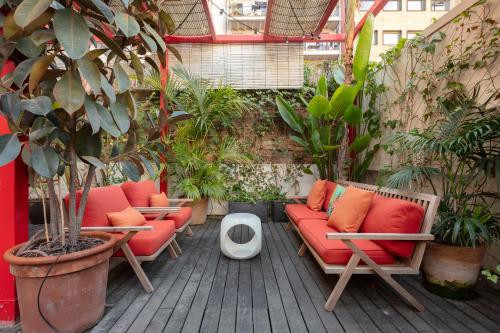 a patio with red couches and potted plants at Praktik Garden in Barcelona