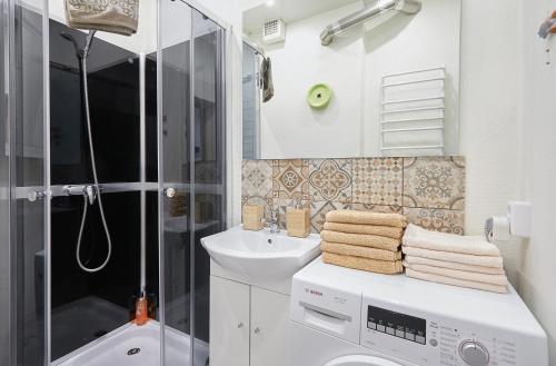 y baño con lavadora y lavamanos. en Kauko Laiptu Apartamentai, en Kaunas