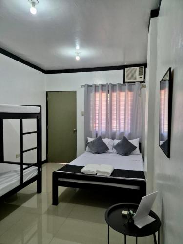 a bedroom with a bed and a laptop on a table at Casa Olivia in Coron