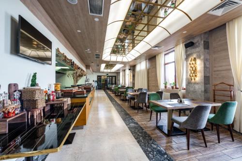 a restaurant with tables and chairs in a room at Wyndham Garden Burabay in Borovoye