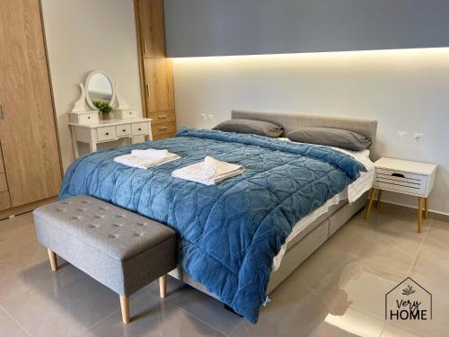 Un dormitorio con una cama grande con un edredón azul. en Veryhome, en Máleme