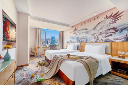 a hotel room with two beds and a mural of birds at 柏高酒店顺德北滘文化公园店 Paco Hotel Shunde Beijiao Midea Group Headquarters store in Shunde