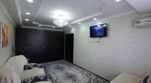 a room with a tv on the wall and a bed at Однокомнатная квартира, Новая! in Mayevka