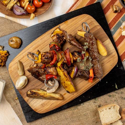 a cutting board with meat and vegetables on a table at Mövenpick Resort Aswan in Aswan