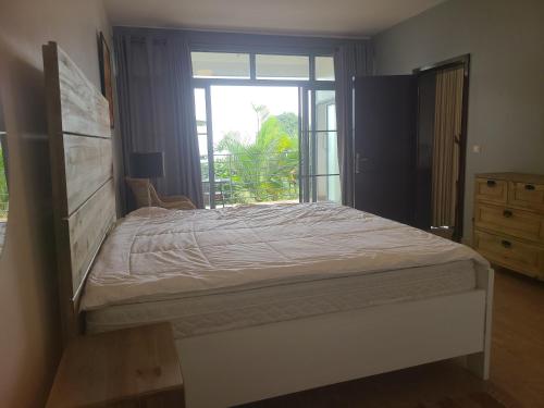 Un dormitorio con una cama grande y una ventana en Rubavu Buy And Sell Ltd, real estate agency, en Gisenyi
