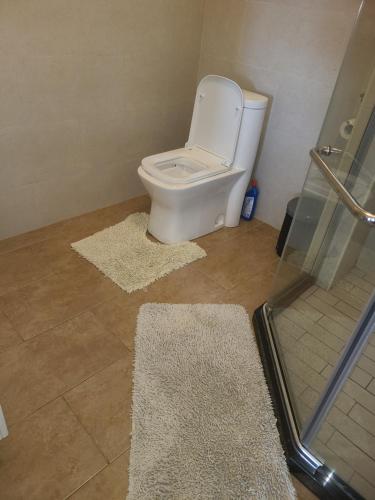 a bathroom with a toilet and a glass shower at Rubavu Buy And Sell Ltd, real estate agency in Gisenyi