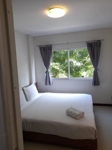 a bedroom with two beds and a window at The September Salaya in Salaya