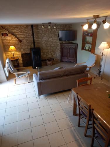 a living room with a couch and a table at Gîte le Four d'Odilon in La Malène