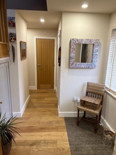 a hallway with a chair and a mirror at West Haven in Sheriff Hutton