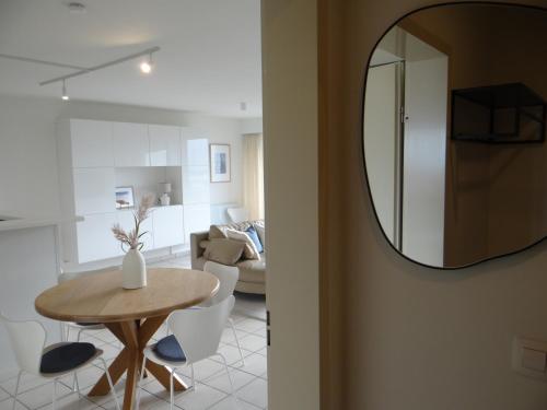 a living room with a table and a mirror at Kom tot rust in een heerlijk verblijf - Toplocatie met zonneterras! in Nieuwpoort