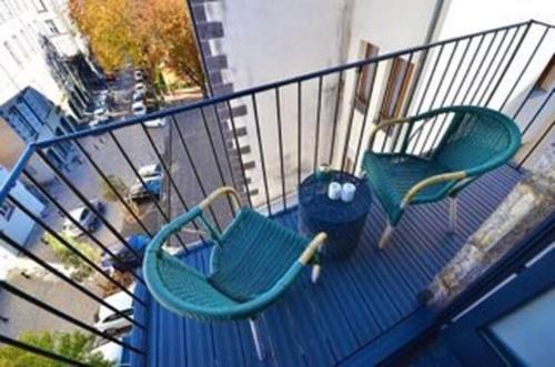 2 chaises assises sur le balcon d'un bâtiment dans l'établissement La Tour Grégoire, à Clermont-Ferrand