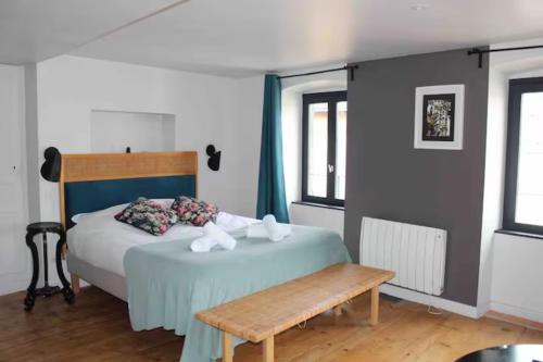 a bedroom with a bed and a wooden bench at La Tour Grégoire in Clermont-Ferrand