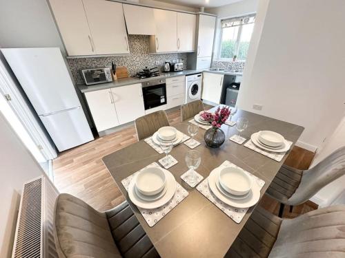 a kitchen with a dining room table with plates on it at No.32 by Blue Skies Stays in Bowburn
