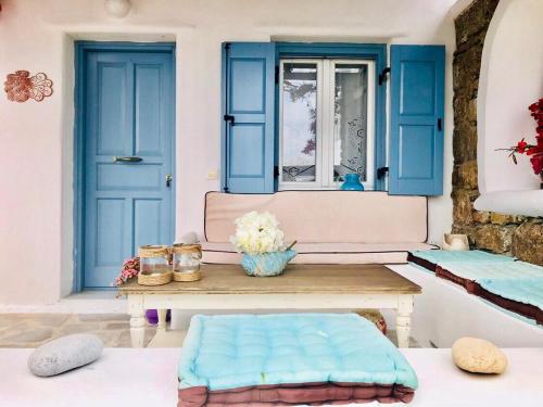 a room with blue doors and a table with pillows at Beautiful Traditional Apt in Ano Mera Mikonos in Ano Mera