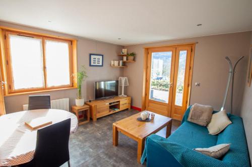 un salon avec un canapé bleu et une table dans l'établissement Le Berceau Savoyard - Annecy, à Nâves-Parmelan