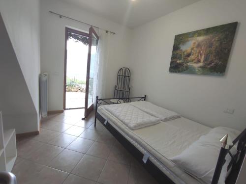 een slaapkamer met een bed en een schilderij aan de muur bij Casa MK & MK Ferienwohnung lake view swimming pool in Pieve