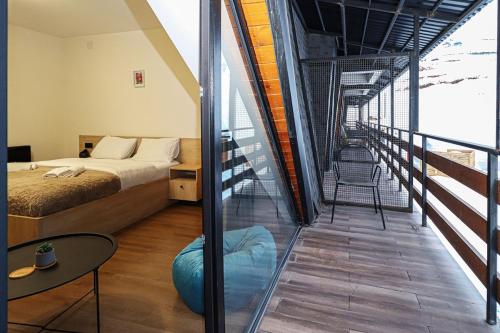 a bedroom with a bed and a balcony with a staircase at Marshall Gudauri Stylish Apartment By Wehost in Gudauri