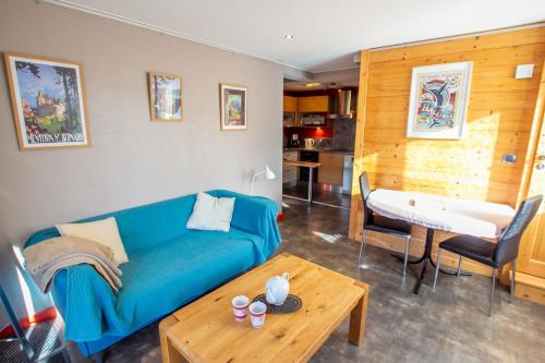 un salon avec un canapé bleu et une table dans l'établissement Le Berceau Savoyard - Annecy, à Nâves-Parmelan