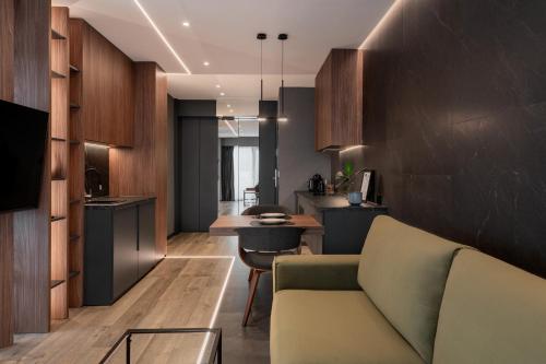 a living room with a couch and a kitchen at Boudoir Apartment City Tower - 15th floor in Cluj-Napoca