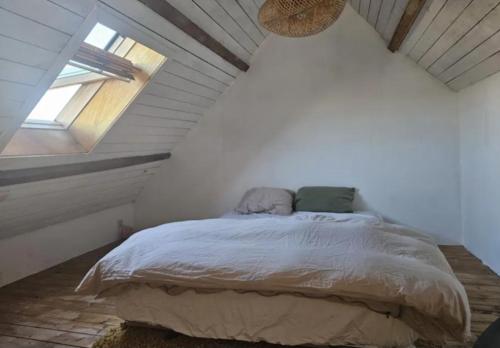 ein Schlafzimmer mit einem Bett im Dachgeschoss mit einem Fenster in der Unterkunft Sunny Penthouse with terras in Gent