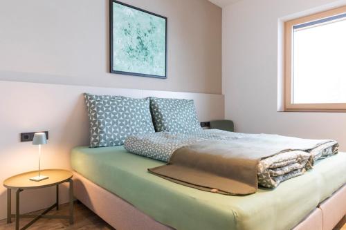 1 dormitorio con 1 cama con mesa y ventana en Ankemma - eure Ferienapartments in Grins, en Grins
