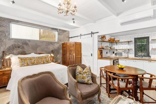 a bedroom with a bed and a table and chairs at Maison Dandelion in Franschhoek