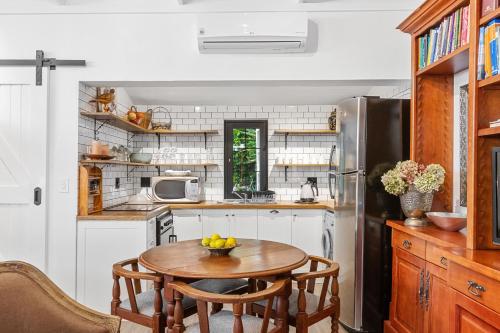 a kitchen with a table and a refrigerator at Maison Dandelion in Franschhoek