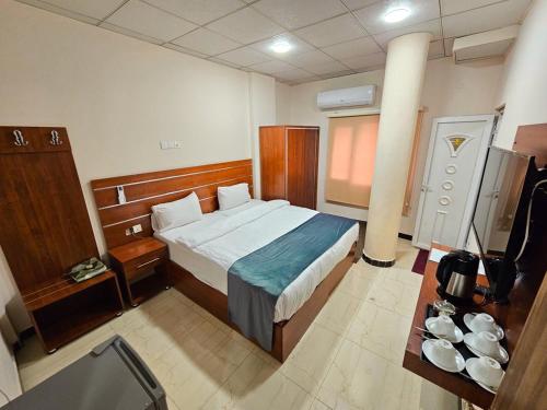 a hotel room with a bed and a table at Villa Hotel Basra in Al Başrah