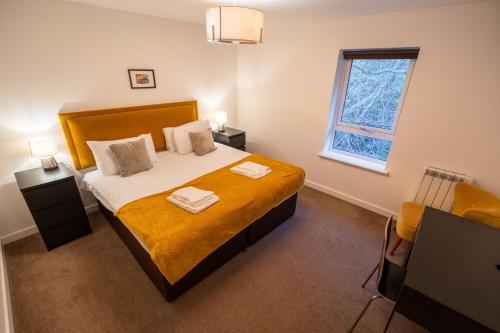 a bedroom with a large bed and a window at Dalwhinnie Apartment in Oban