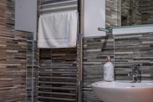 a bathroom with a sink and a mirror at Dalwhinnie Apartment in Oban