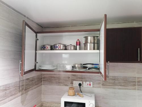 a kitchen with a microwave and some pots and pans at الخوض السادسة واحة المعرفة in Al Khawḑ