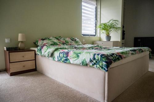 - une chambre avec un lit et une plante dans l'établissement WILLA BIAŁY DOM, à Cracovie