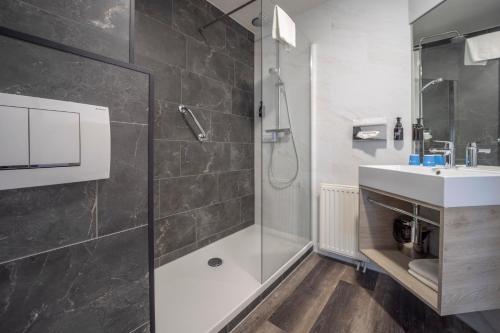 a bathroom with a shower and a sink at Fletcher Hotel - Restaurant de Zeegser Duinen in Zeegse