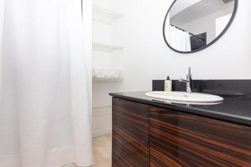 a bathroom with a sink and a mirror on a dresser at 1 BDRM Apartment - heart of Downtown - 5 min to Wynwood in Miami