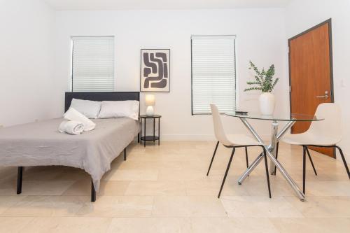 um quarto com uma cama e uma mesa de vidro em 1 BDRM Apartment - heart of Downtown - 5 min to Wynwood em Miami