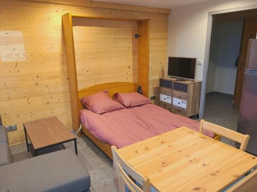 Schlafzimmer mit einem Bett, einem Tisch und einem TV in der Unterkunft Résidence Croix Margot in Villard-de-Lans