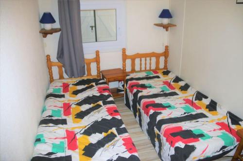 deux lits côte à côte dans une pièce dans l'établissement Villa Azur et soleil, Cap d'Agde, au Cap d'Agde