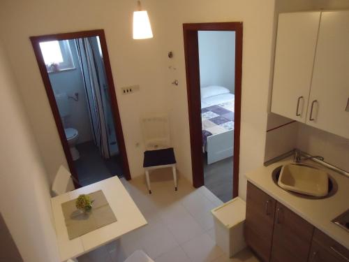 a small bathroom with a sink and a mirror at Apartments Mirela in Novigrad Istria