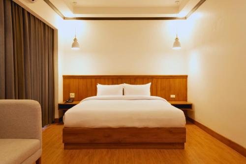 een slaapkamer met een groot bed met witte lakens bij Oudomsin VangVieng Hotel in Vang Vieng