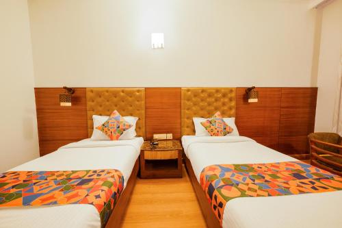 ein Hotelzimmer mit 2 Betten und einem Tisch in der Unterkunft FabHotel Royale Basant Residency in Bangalore