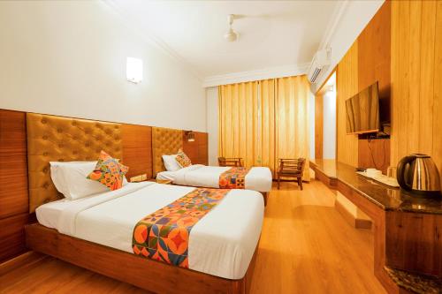 a hotel room with two beds and a television at FabHotel Royale Basant Residency in Bangalore
