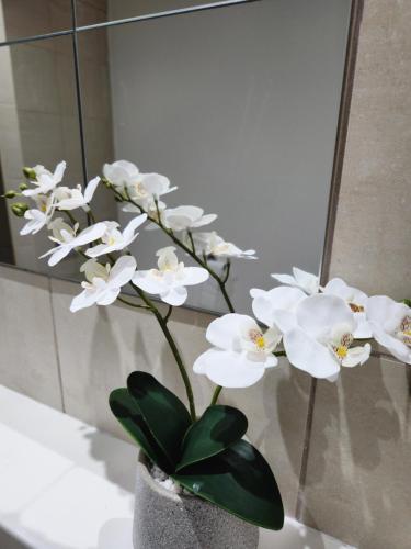 un vase rempli de fleurs blanches devant un miroir dans l'établissement Stylish 2 bed & 2 bath City Centre Apartment with FREE PARKING, à Sheffield