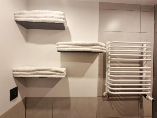 uma casa de banho com toalhas brancas numa parede em Na Szczycie em Chełm