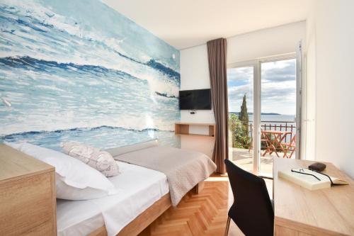 a bedroom with a large painting of the ocean at Villa Maestral with pool Ciovo in Trogir