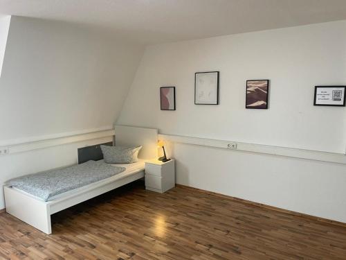 ATRIUM - gemütliche Wohnung RHEINHORST LINKS في لودفيغسهافن أم راين: غرفة نوم بسرير ومصباح على أرضية خشبية
