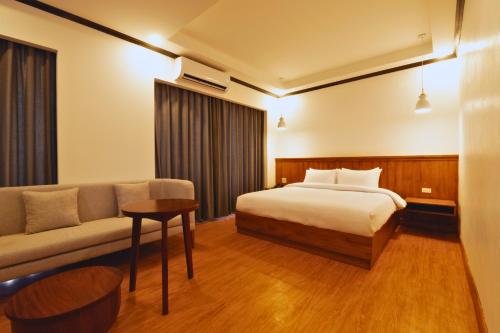 een hotelkamer met een bed en een bank bij Oudomsin VangVieng Hotel in Vang Vieng