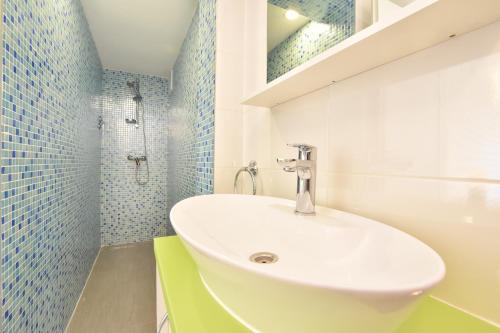 a white sink in a bathroom with blue tiles at Villa Maestral with pool Ciovo in Trogir