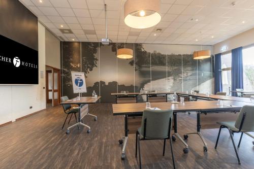 a conference room with tables and chairs and a screen at Fletcher Hotel - Restaurant de Zeegser Duinen in Zeegse
